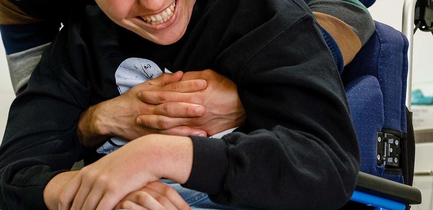 Kind und Betreuer. Kind lächelt. Bild zum Thema Inklusion als Menschenrecht. 