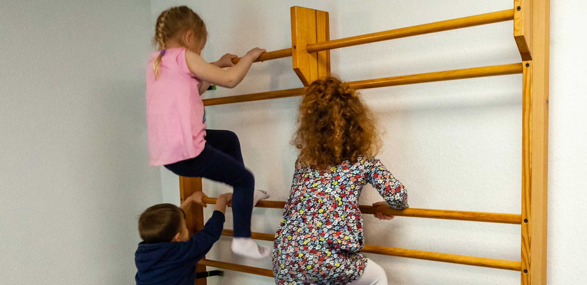 3 Kinder an einer Sprossenwand